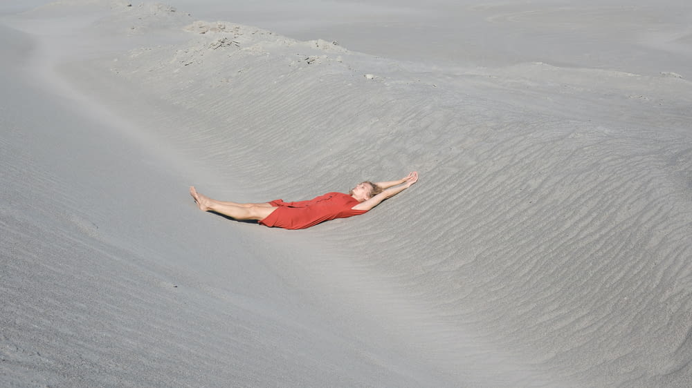 Un hombre está acostado en la arena