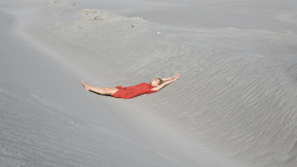 a man is laying down in the sand