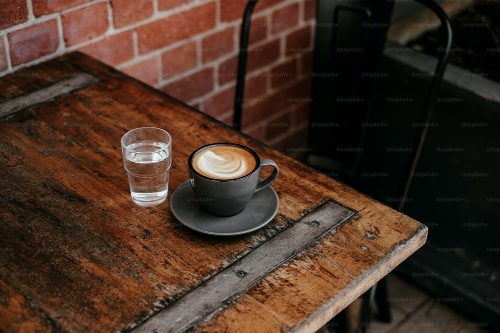 una tazza di caffè e un bicchiere d'acqua su un tavolo