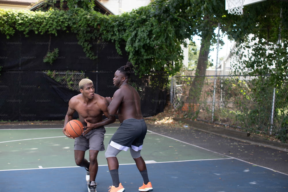 um casal de homens em cima de uma quadra de basquete