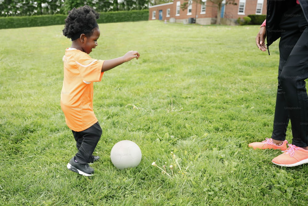 a little boy kicking a soccer ball in a field