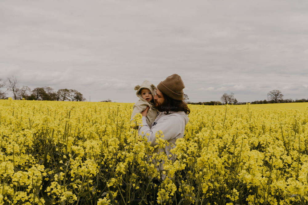Un hombre y una mujer parados en un campo de flores amarillas
