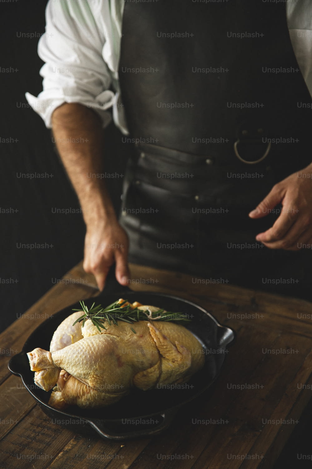 a man in an apron is cooking a turkey