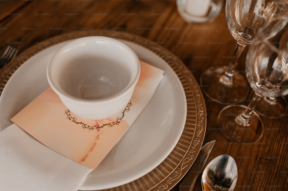 a white plate topped with a white cup and saucer
