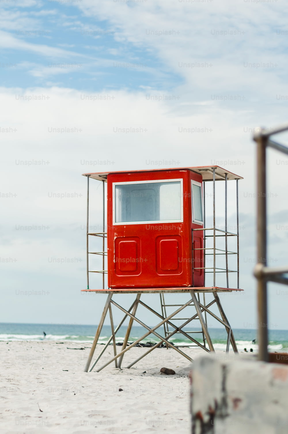 a lifeguard tower on the beach with a sky background