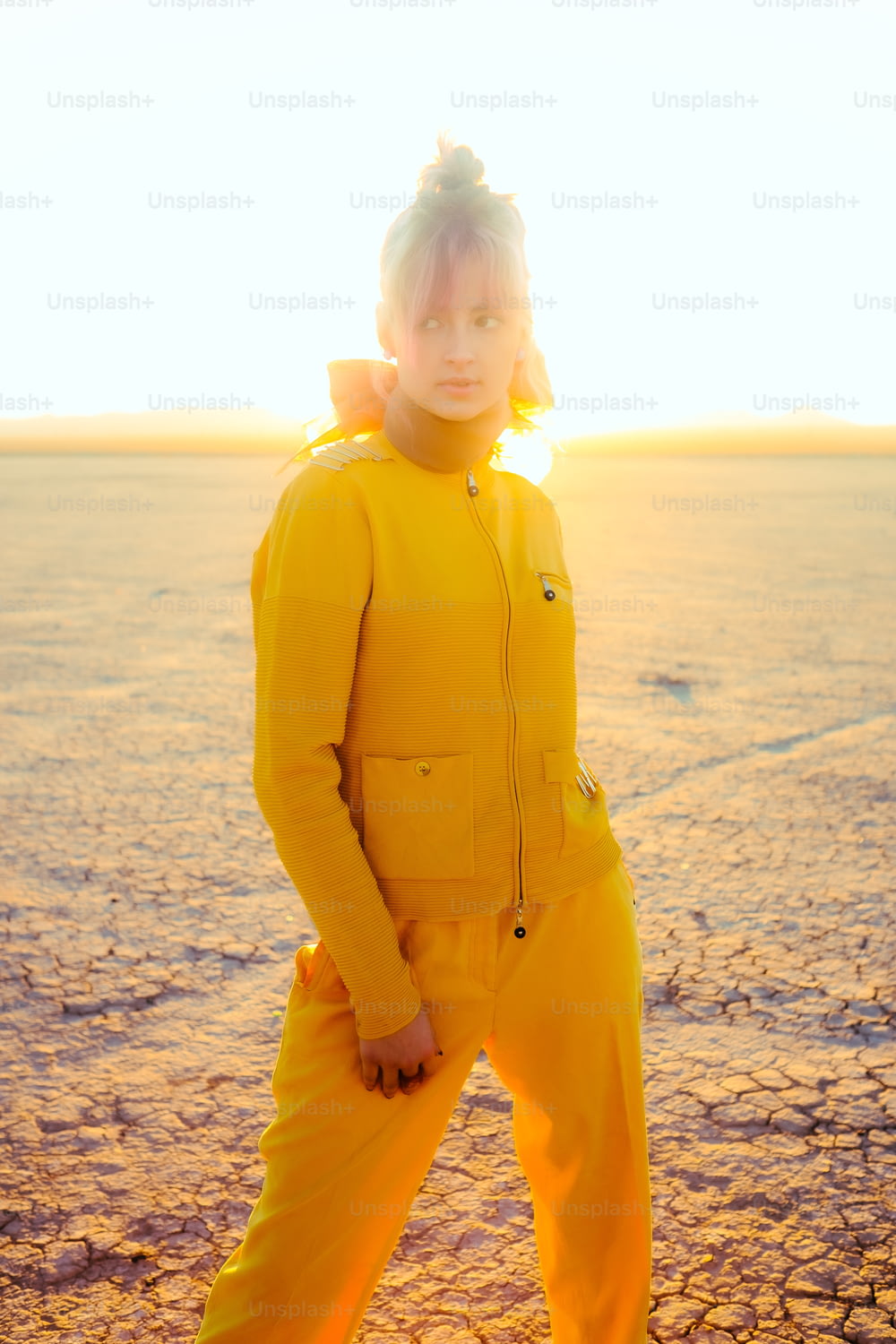 a person in a yellow suit standing in the desert