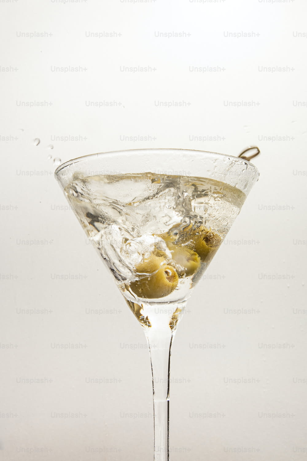 un bicchiere da martini pieno di ghiaccio e olive