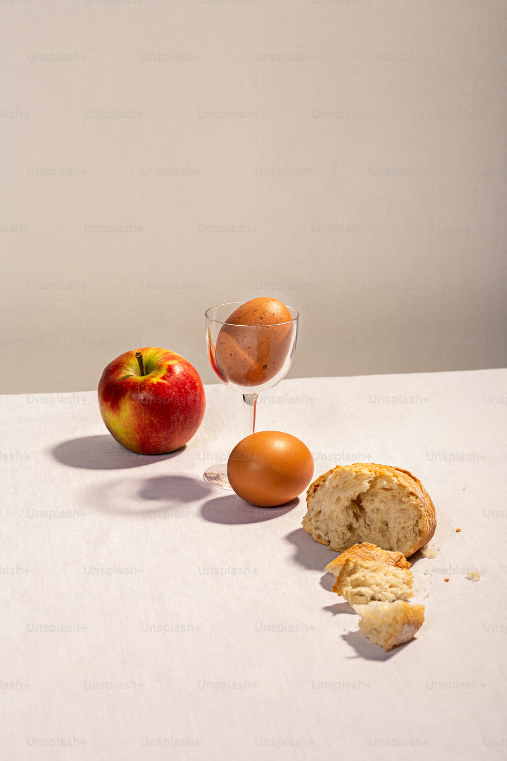 uma mesa coberta com uma maçã e um muffin ao lado de um ovo