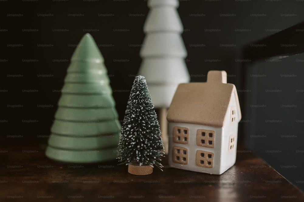 Una pequeña casa junto a un pequeño árbol de Navidad