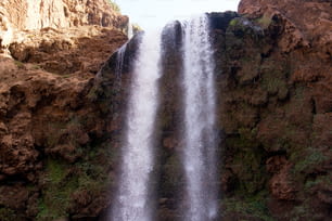 a large waterfall in the middle of a rocky area