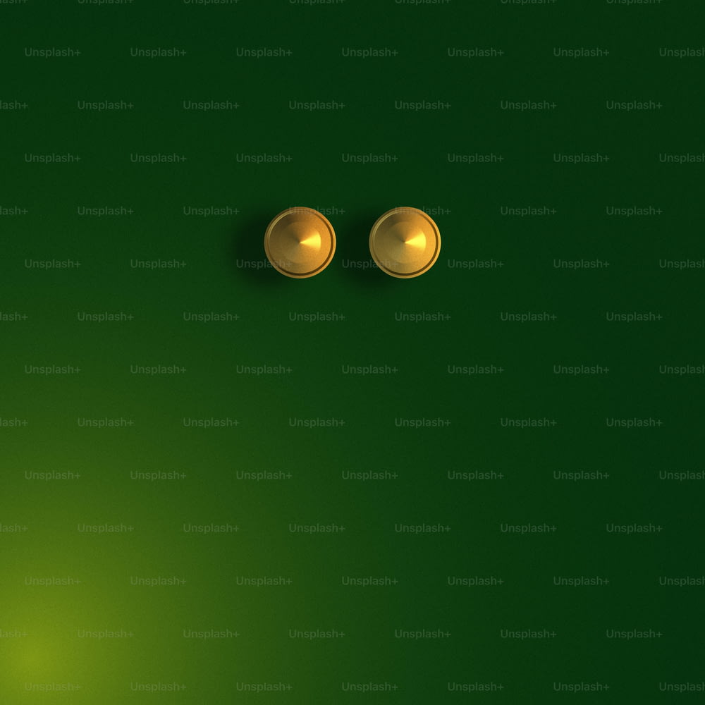 a pair of gold knobs on a green background