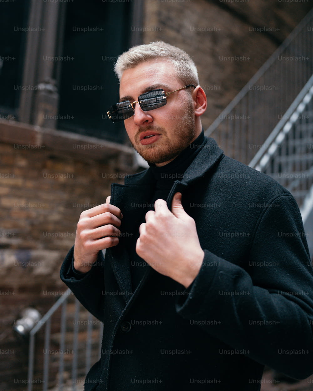 a man in a black coat and sunglasses