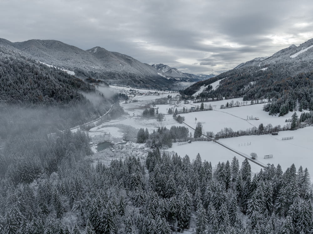 a snow covered valley surrounded by mountains and trees