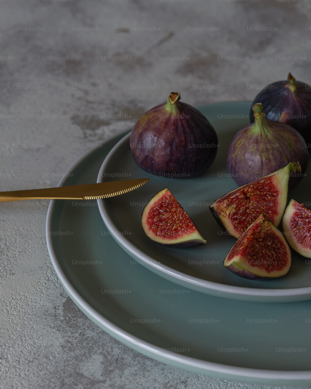 a plate with figs and a knife on it