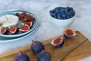 figs, blueberries, cheese and nuts on a cutting board