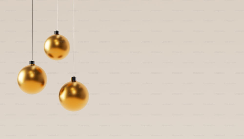 three shiny gold balls hanging from a string
