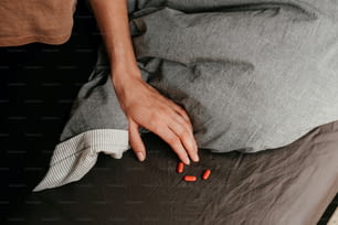 a person laying on a bed with pills in their hand