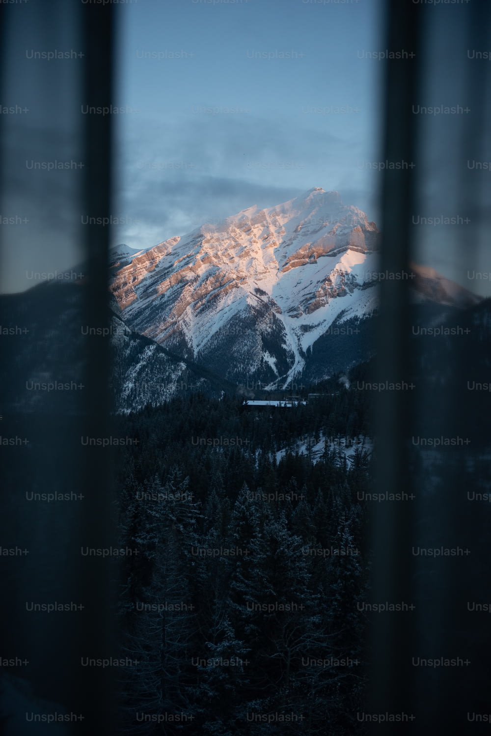 Una ventana con una montaña al fondo