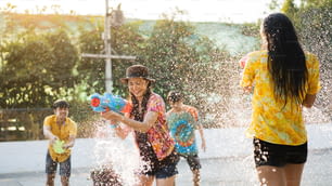 Asiaten benutzen Wasserpistolen spielen Songkran Festival im Sommer April