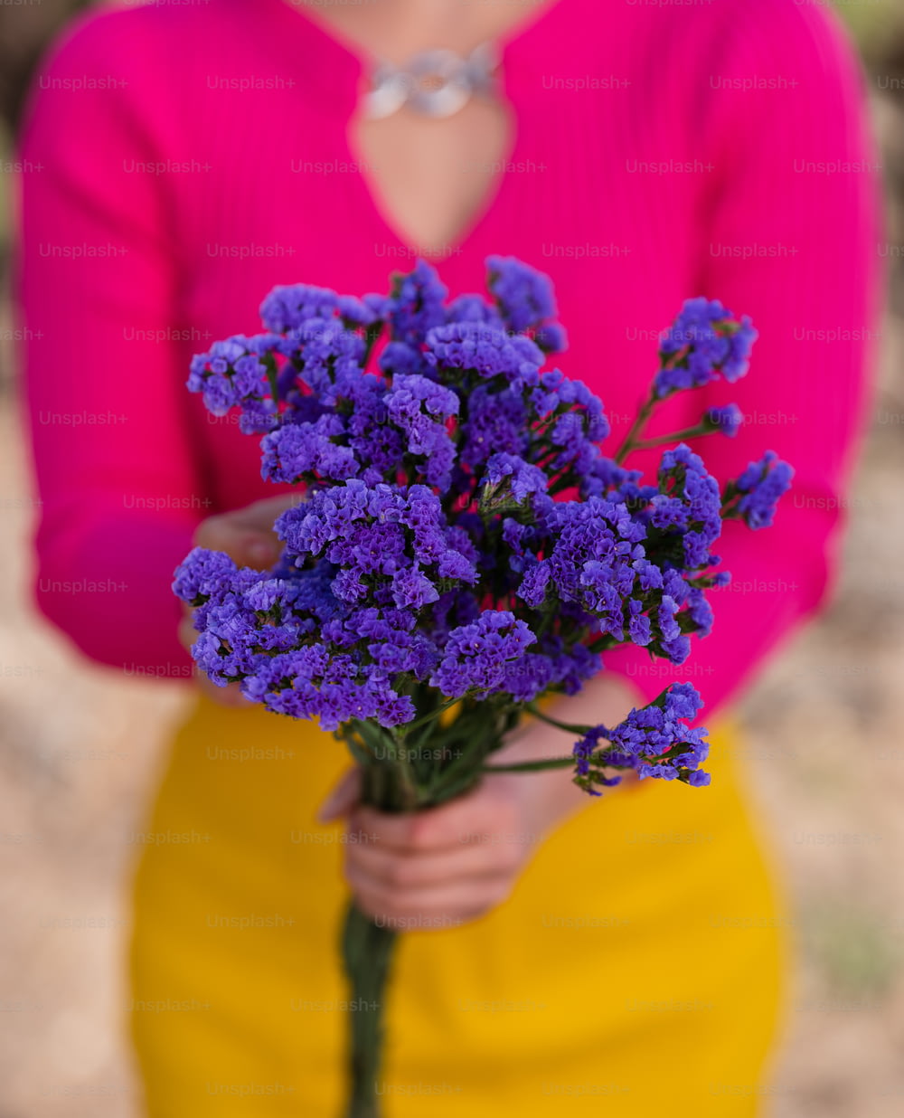 a person holding a bouquet of purple flowers