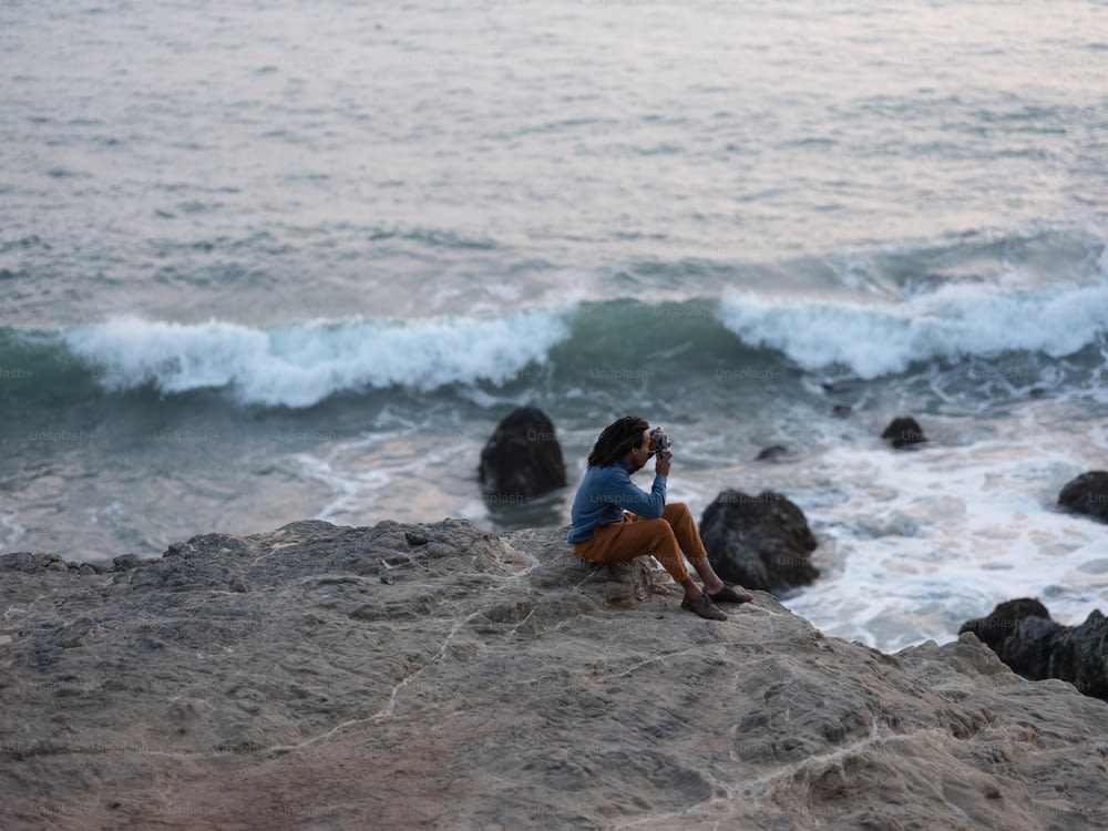 海沿いの岩の上に座っている人