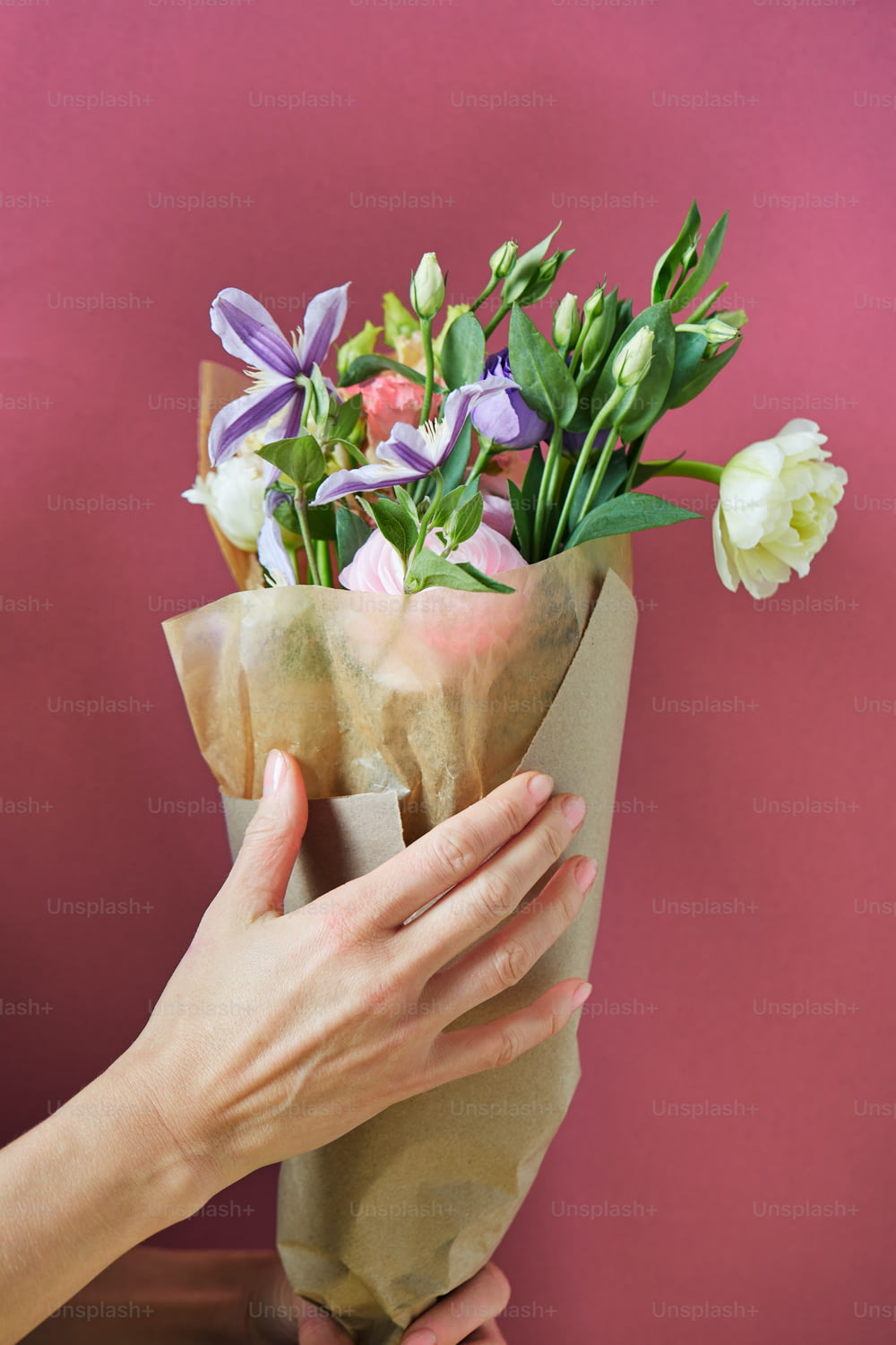 eine Hand, die einen Becher Blumen hält