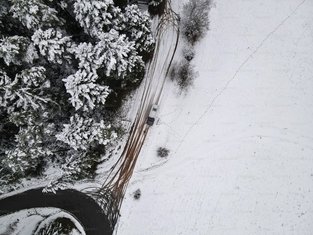 uma vista aérea de um carro dirigindo em uma estrada nevada