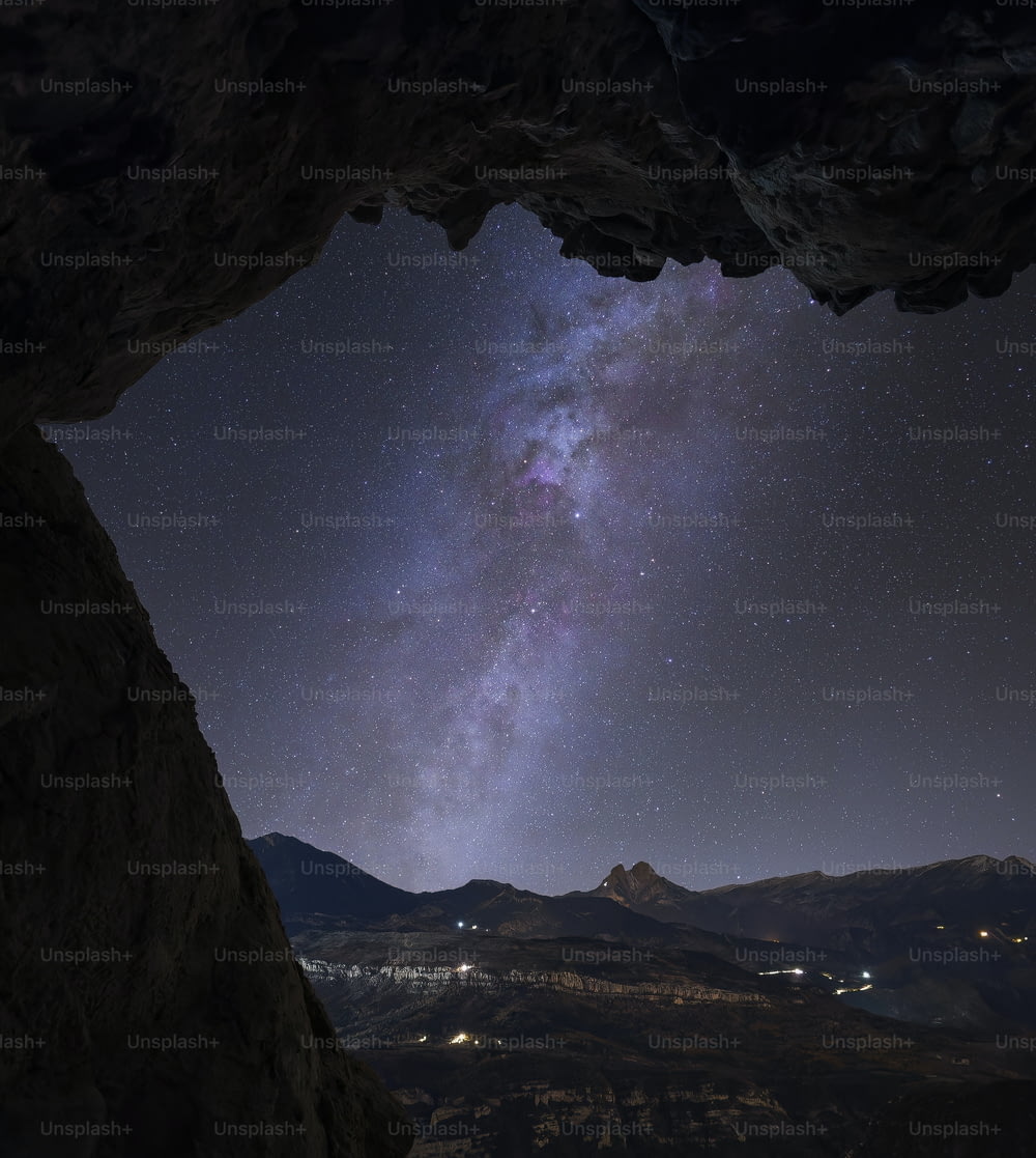 uma vista do céu noturno de dentro de uma caverna