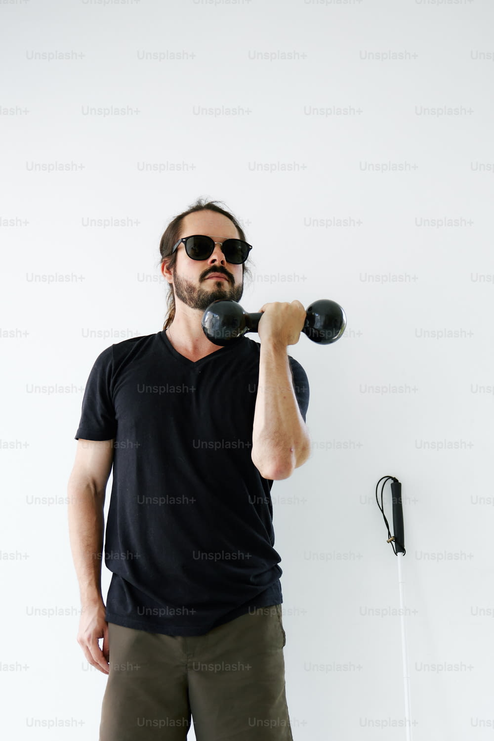 a man holding a pair of dumbbells in his right hand