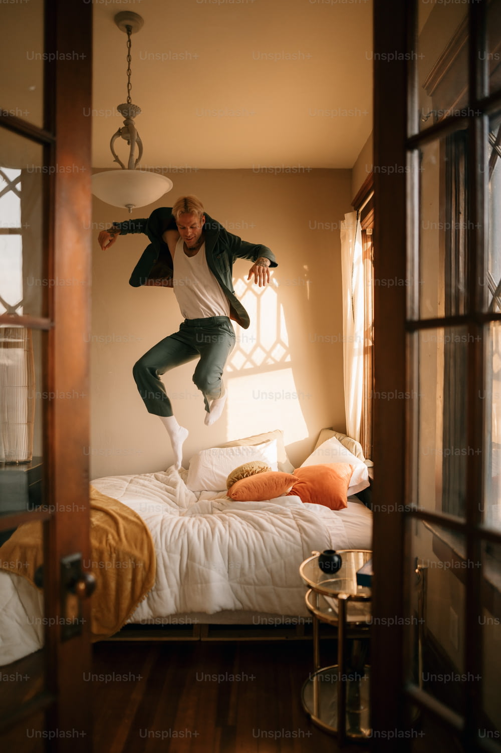 um homem pulando no ar em uma cama