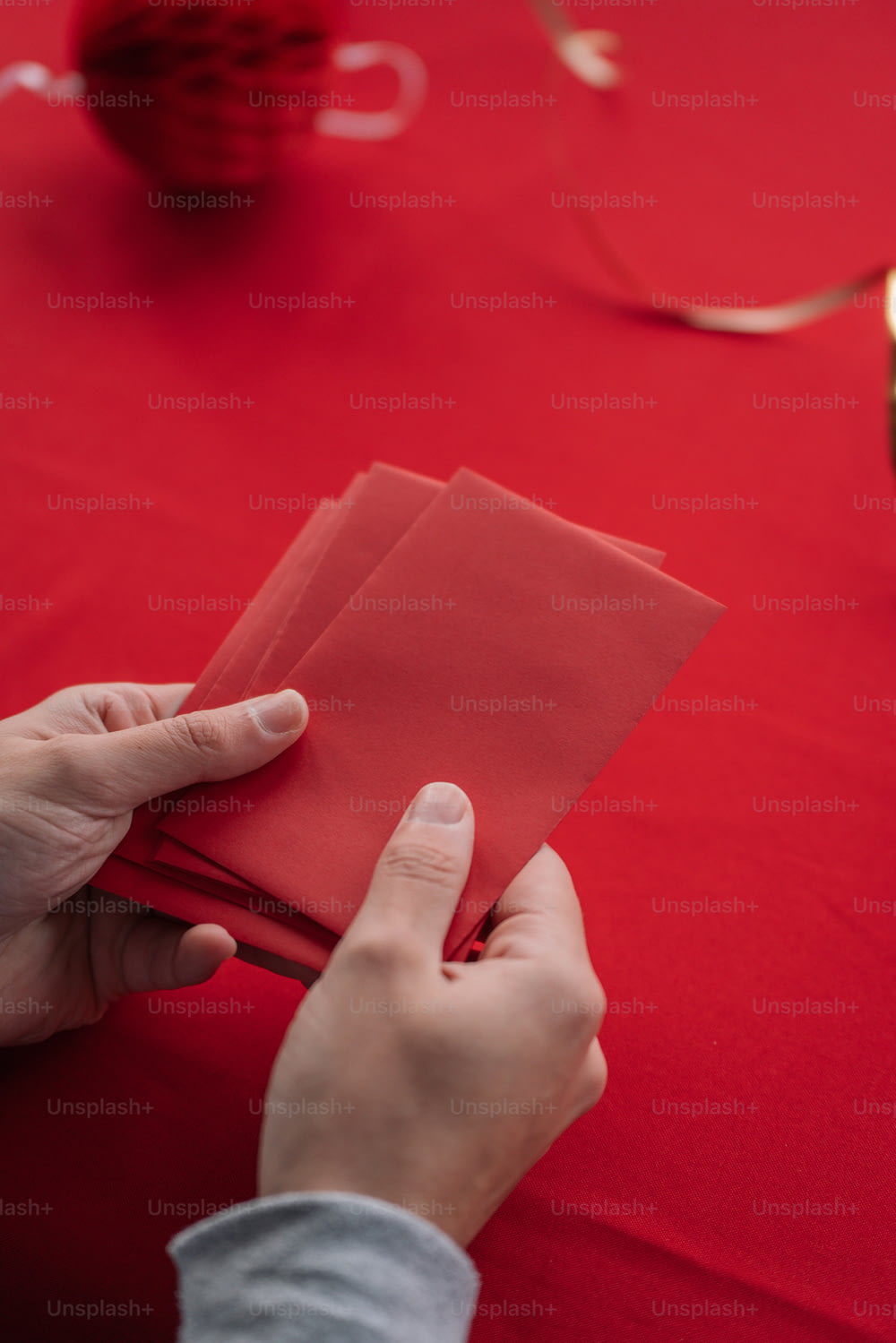 a person is folding a piece of red paper