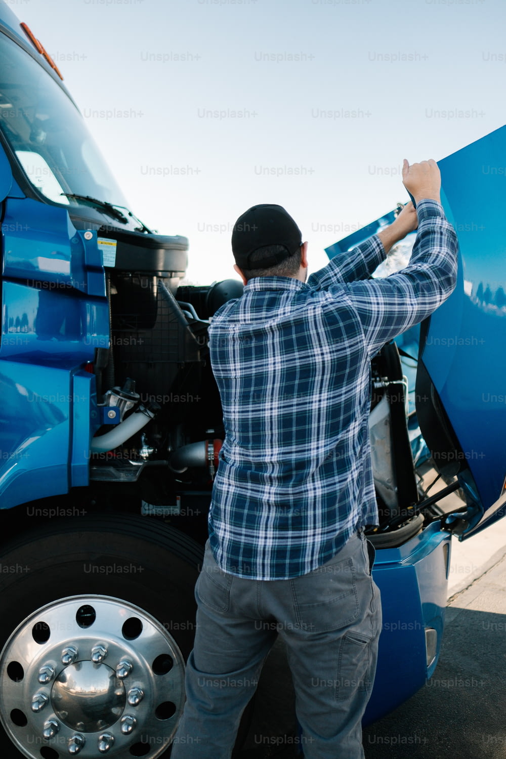 a man standing next to a blue semi truck
