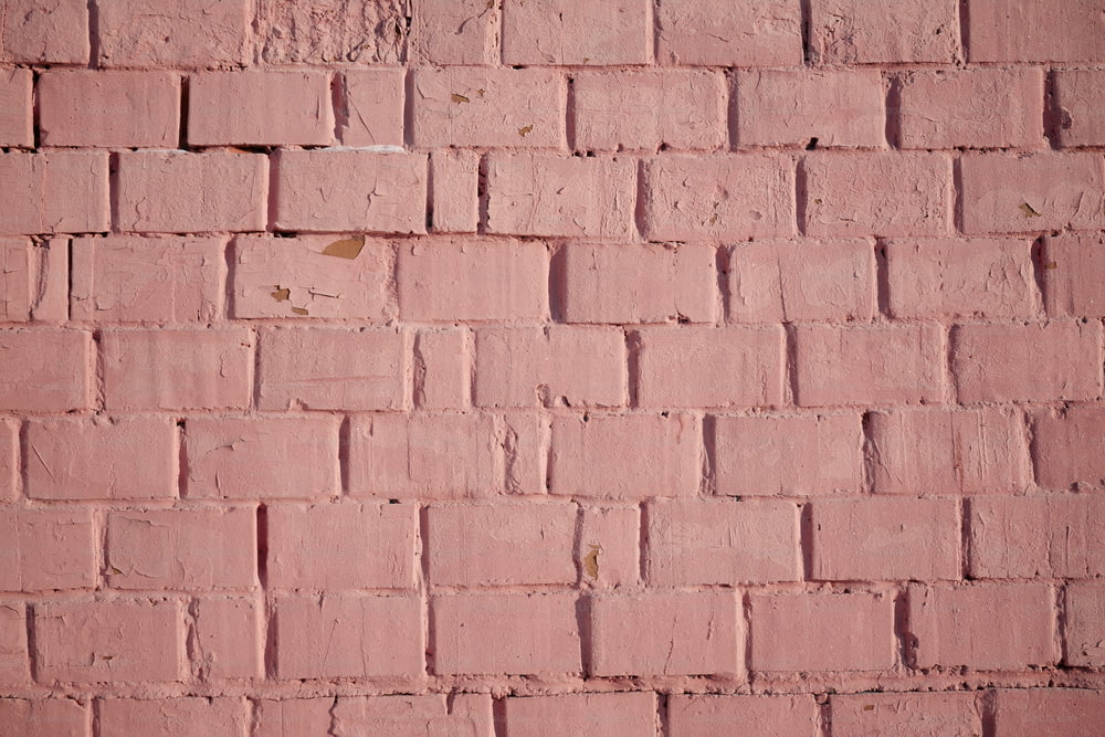 a red brick wall with a small patch of paint on it
