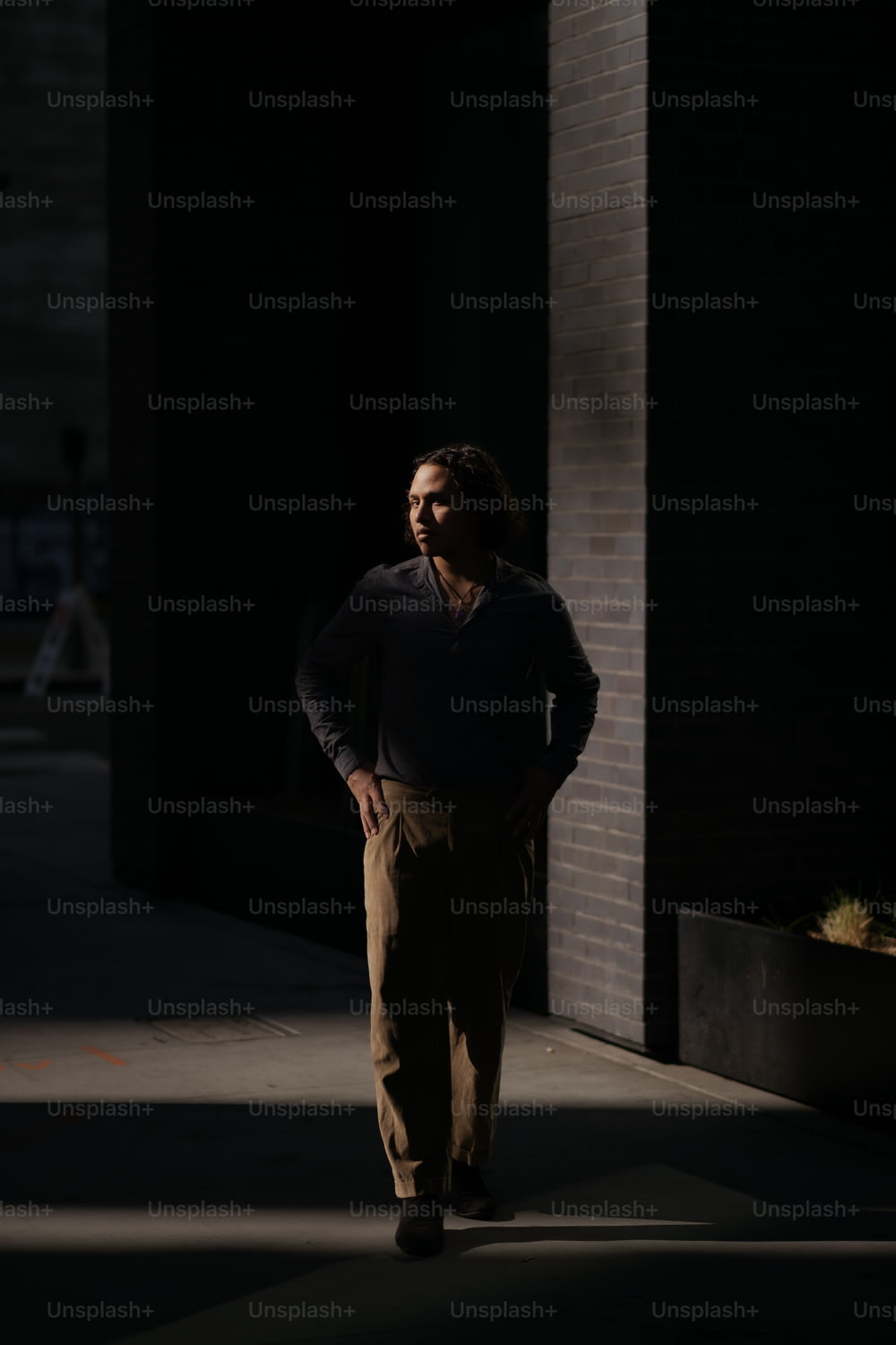 um homem de pé em uma calçada no escuro