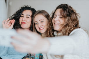 Tres mujeres tomando una foto con su teléfono celular