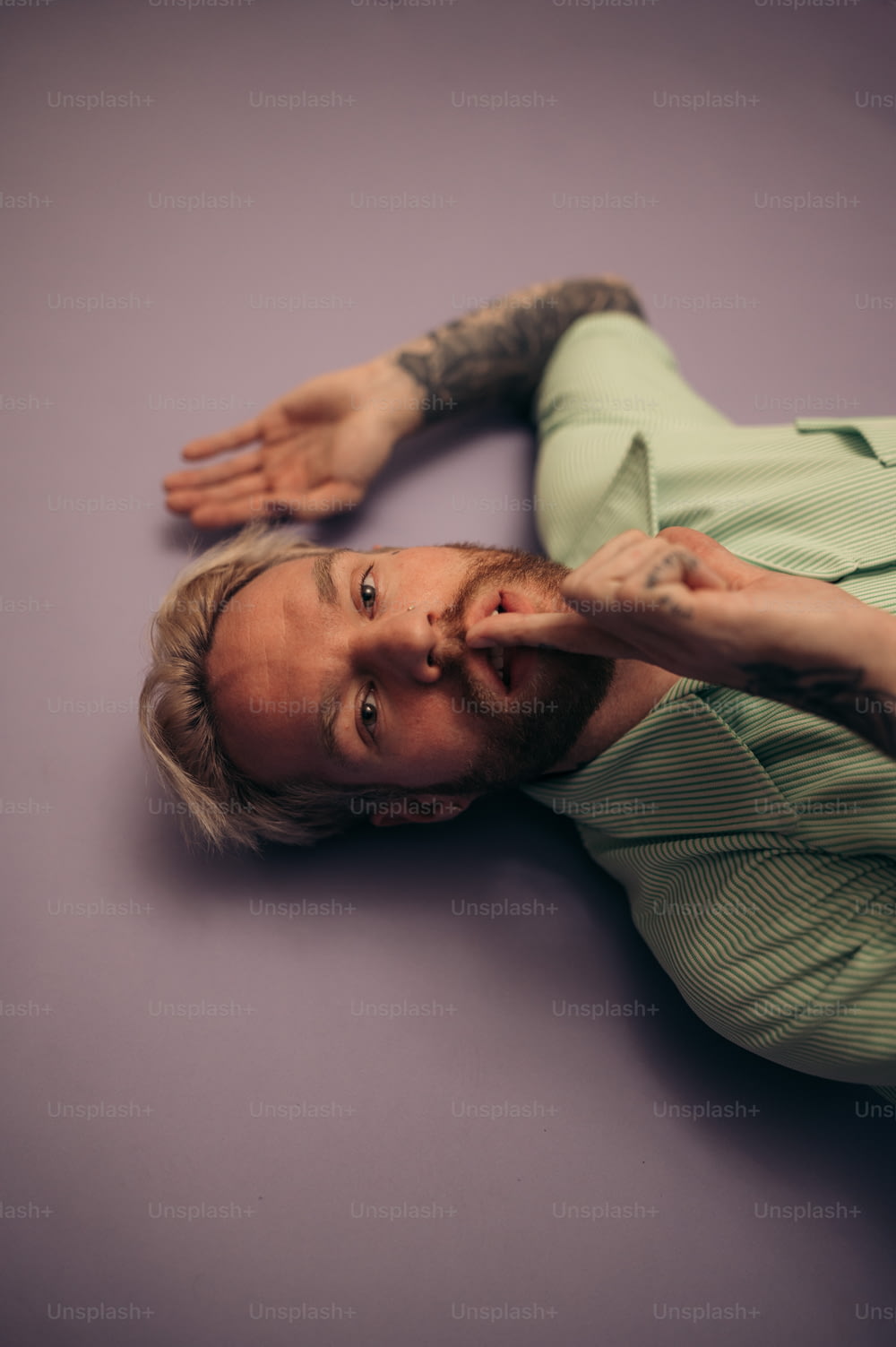 a man laying on the ground with his hand on his forehead