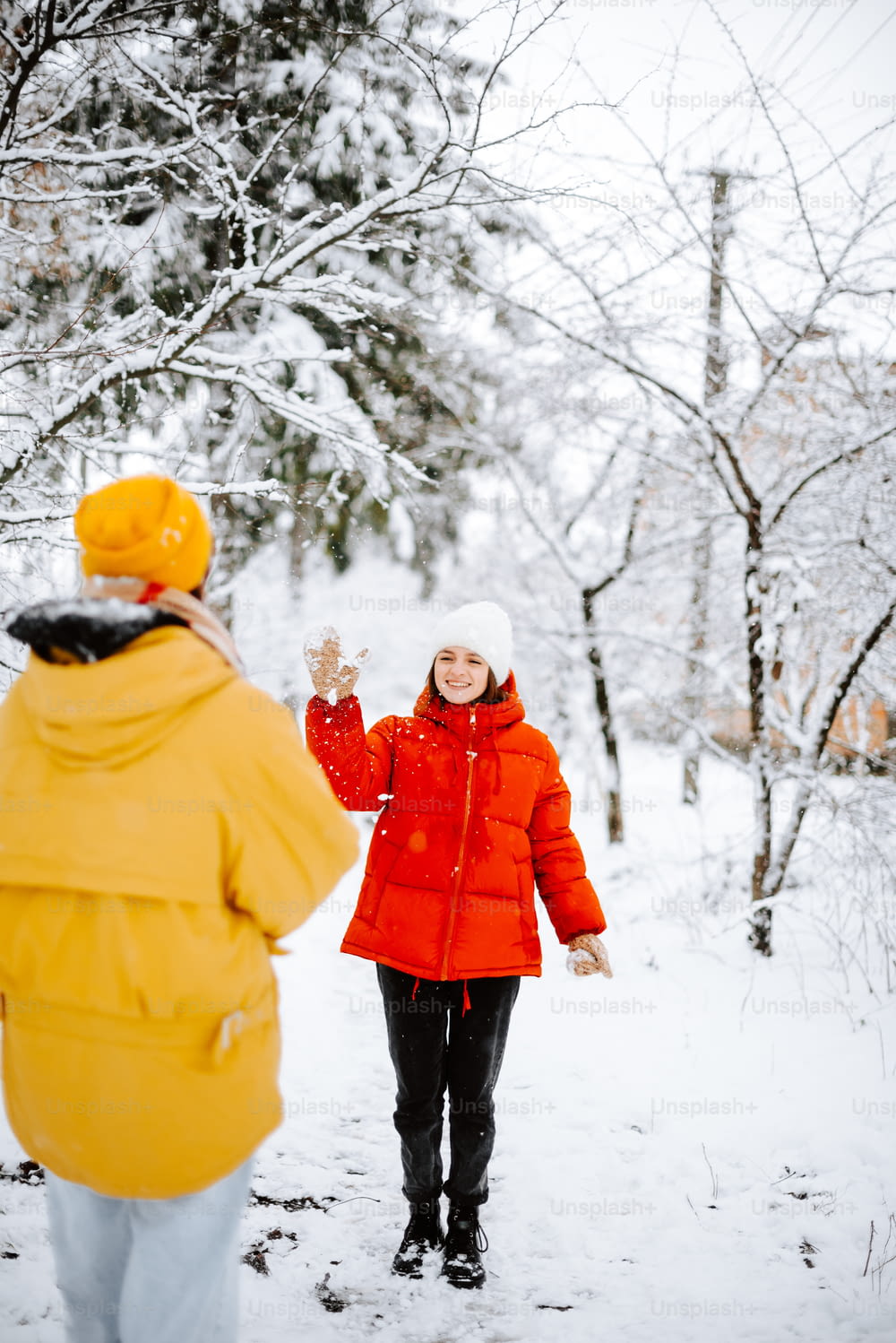 a woman in a red jacket is walking in the snow
