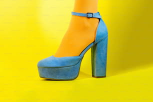 Die blau-gelben Schuhe einer Frau mit hohen Absätzen