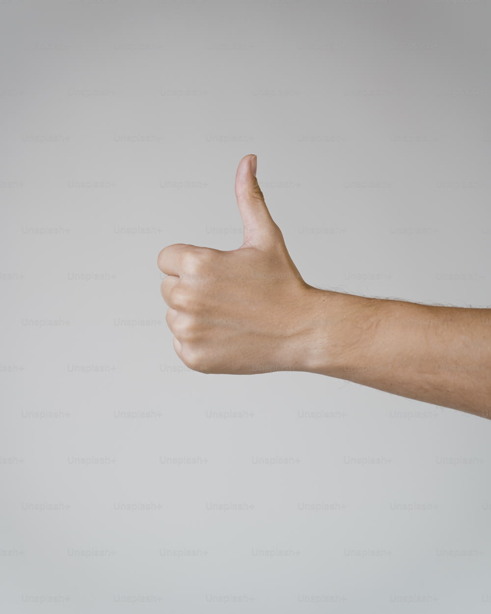 a person's hand giving a thumbs up sign