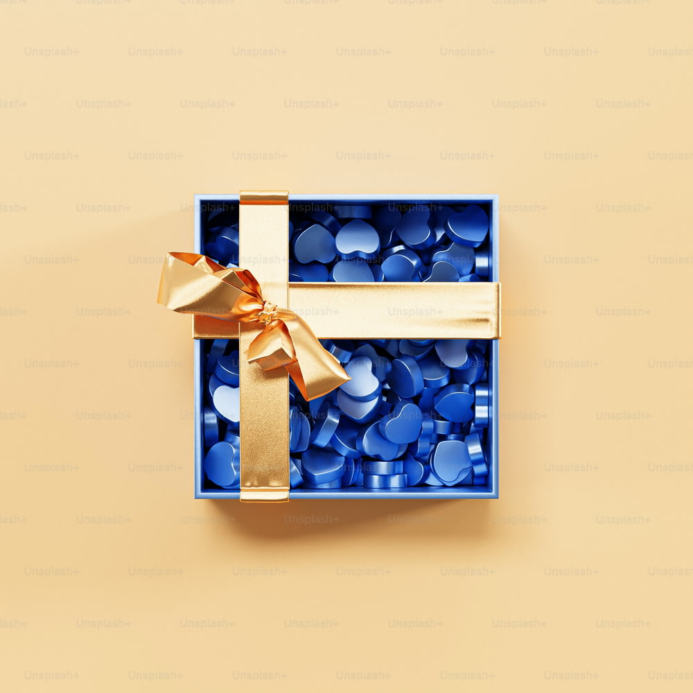 a blue box with a gold ribbon and a bow