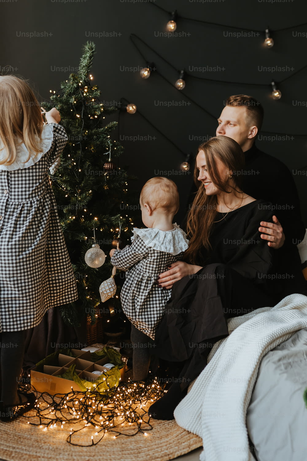 Una familia parada frente a un árbol de Navidad