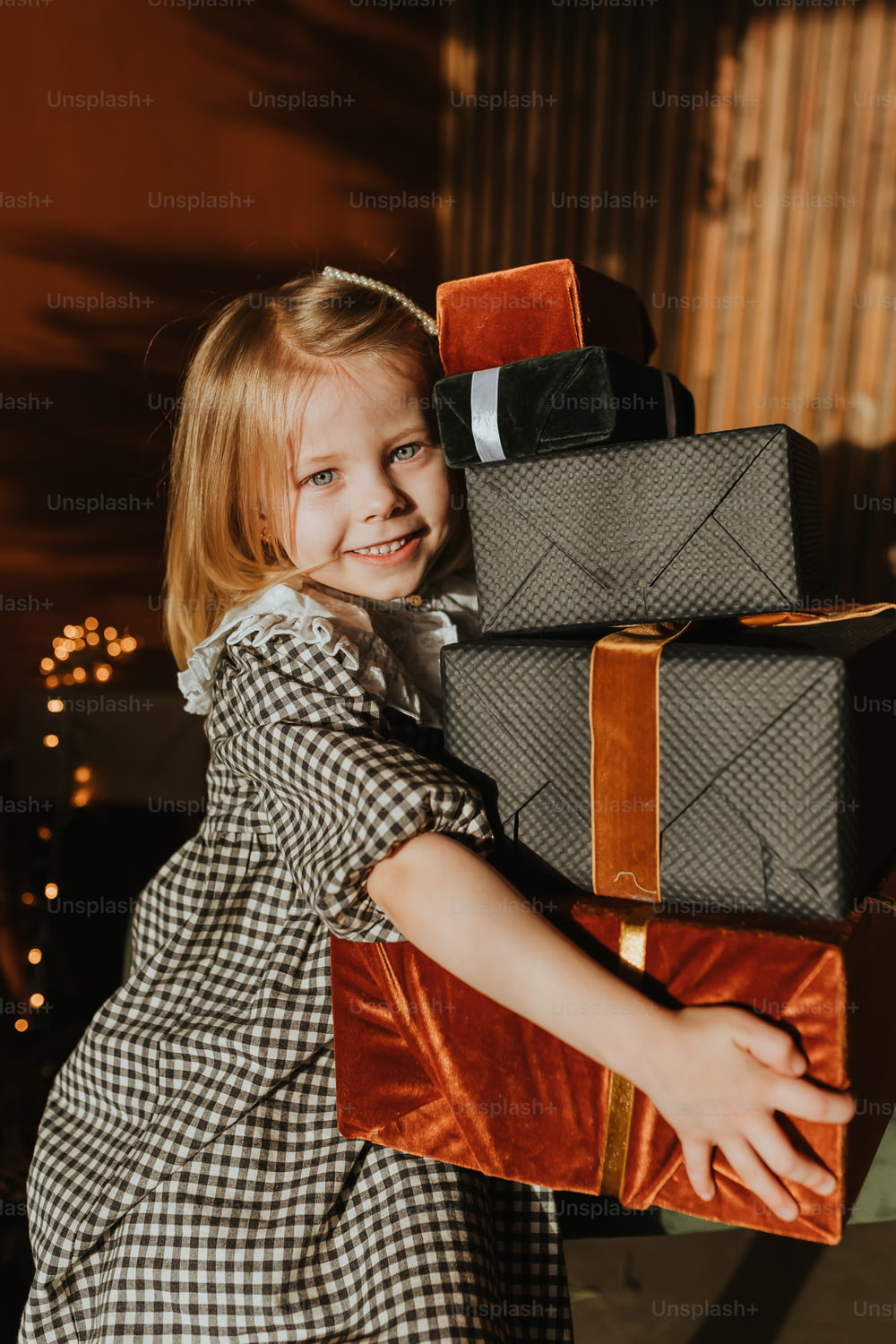 a little girl holding a stack of luggage