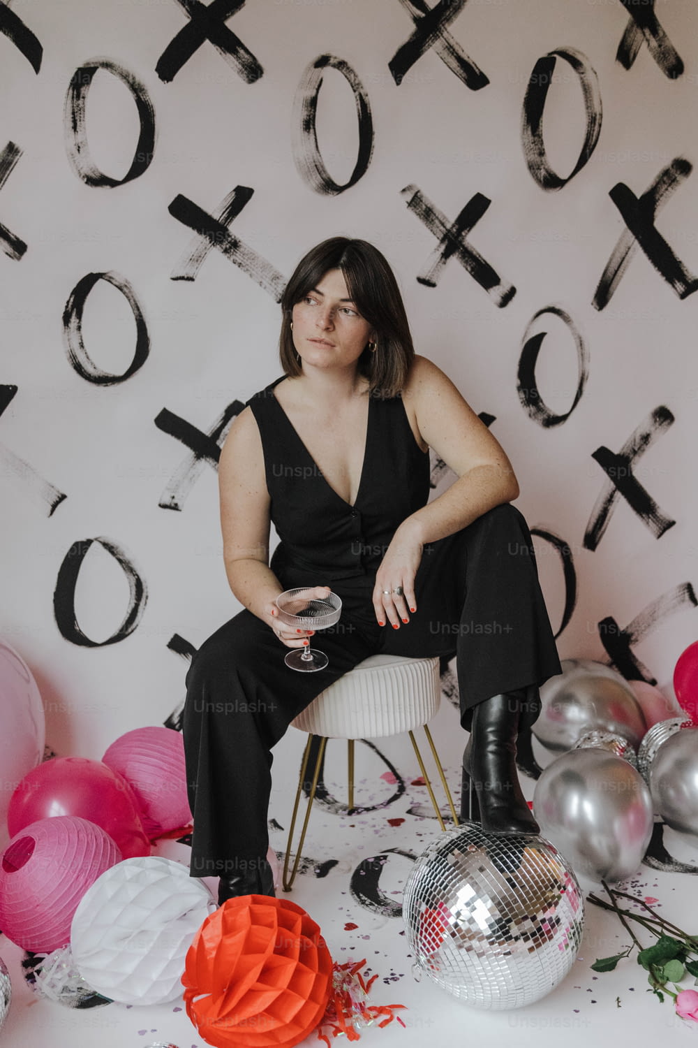 a woman sitting on a chair in front of balloons