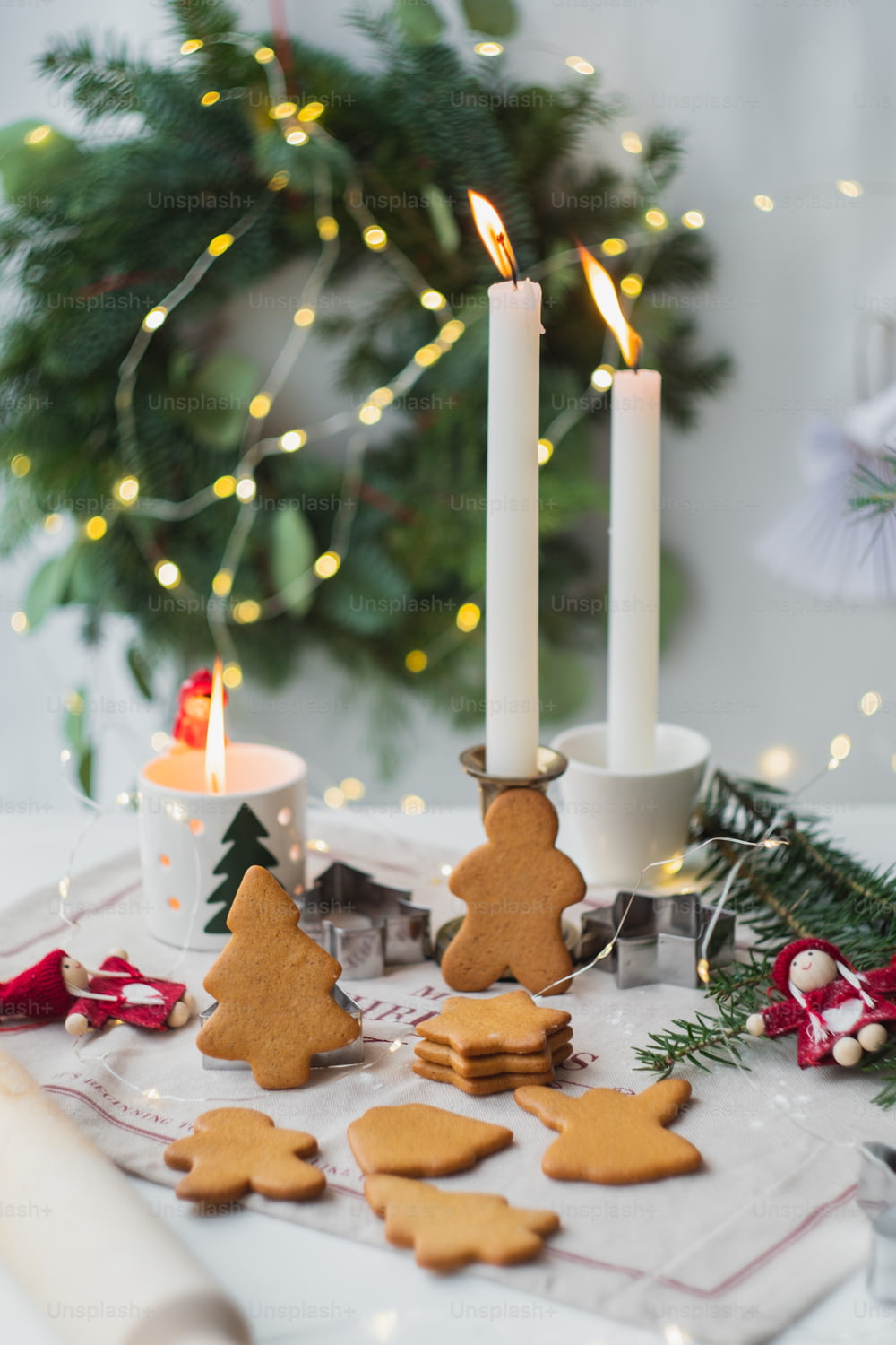 불이 켜진 촛불 옆에 �많은 쿠키가 얹힌 테이블