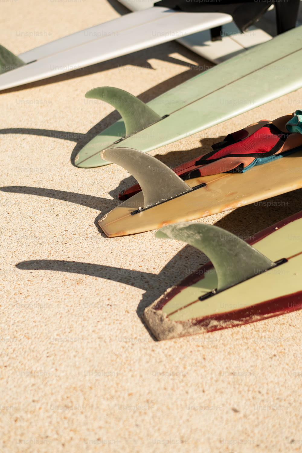Eine Gruppe von Surfbrettern sitzt auf einem Sandstrand