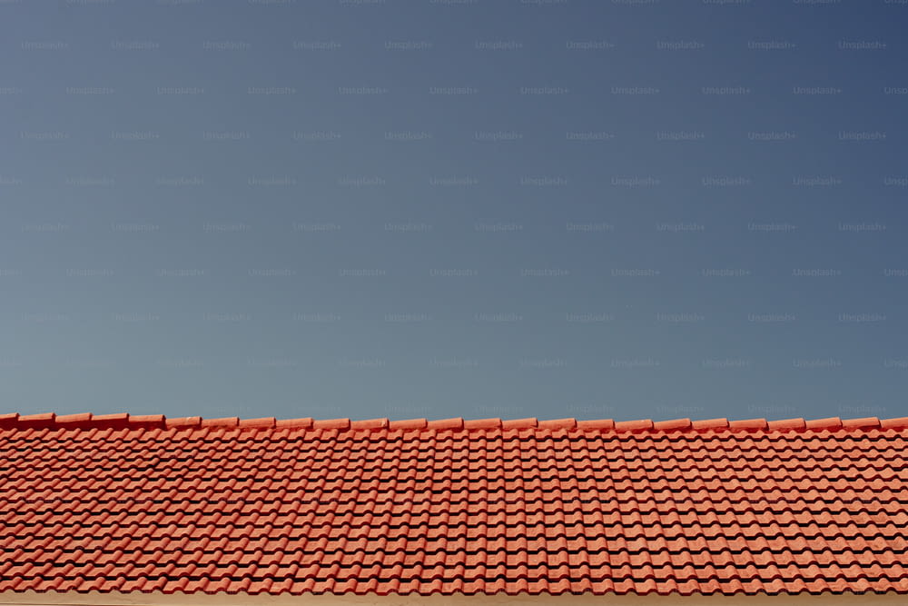 a red roof with a blue sky in the background