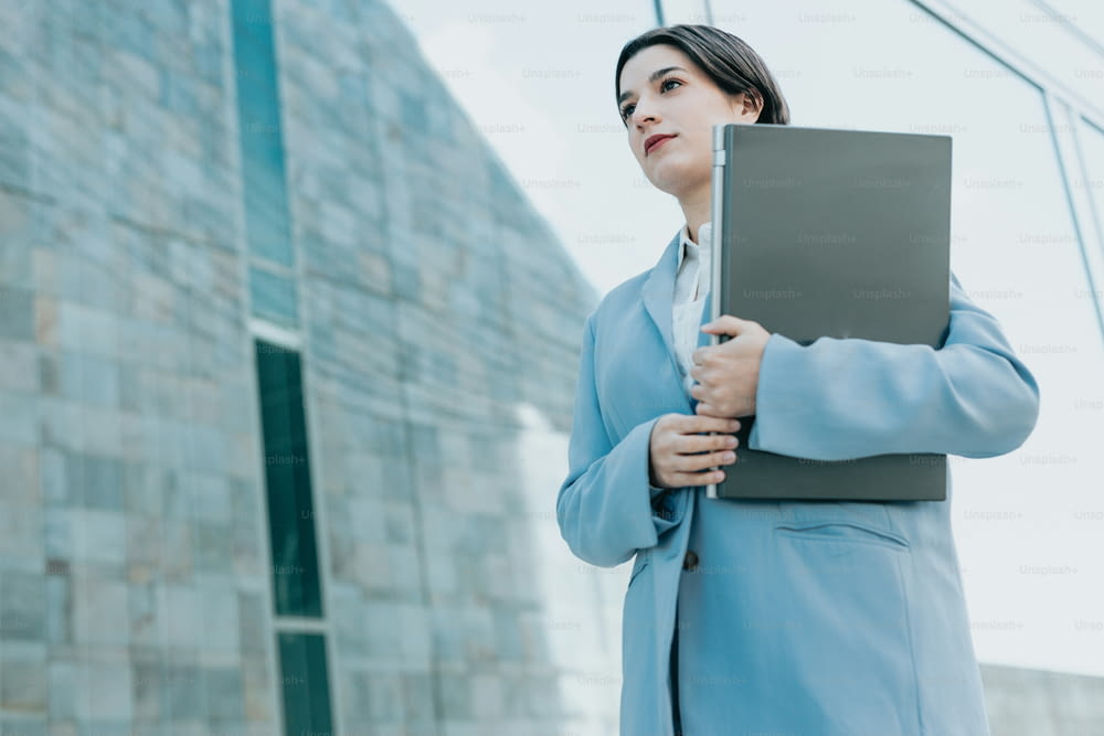 a woman in a business suit holding a binder