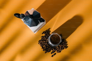 une tasse de café à côté d’un moulin et de grains de café