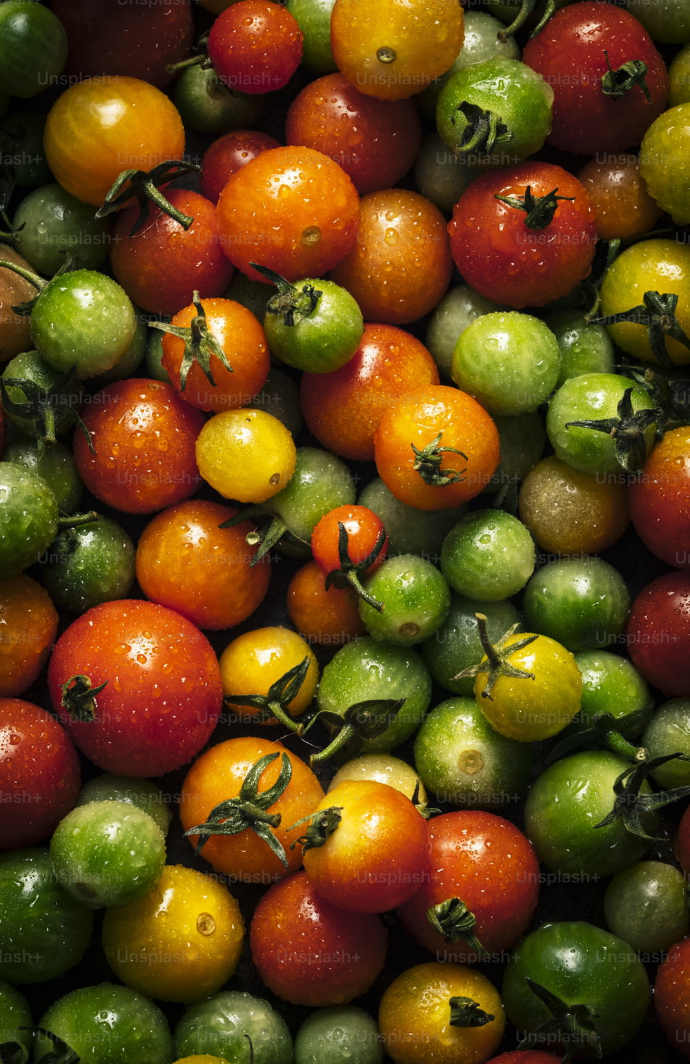 a large pile of tomatoes and other fruits