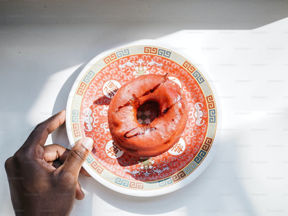 a person holding a plate with a donut on it